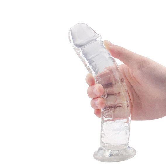 Imagem de uma mão segurando pênis artificial transparente