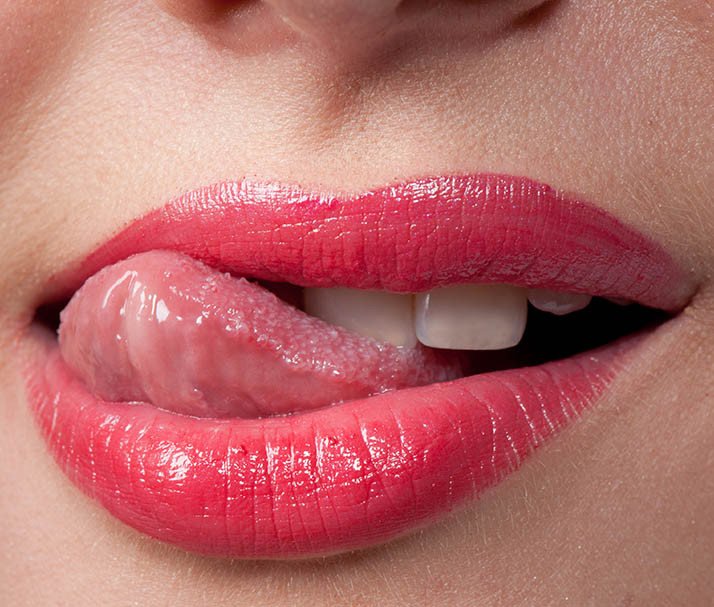 imagem sexy de boca feminina com lábios rosados com a ponta da língua de fora 2