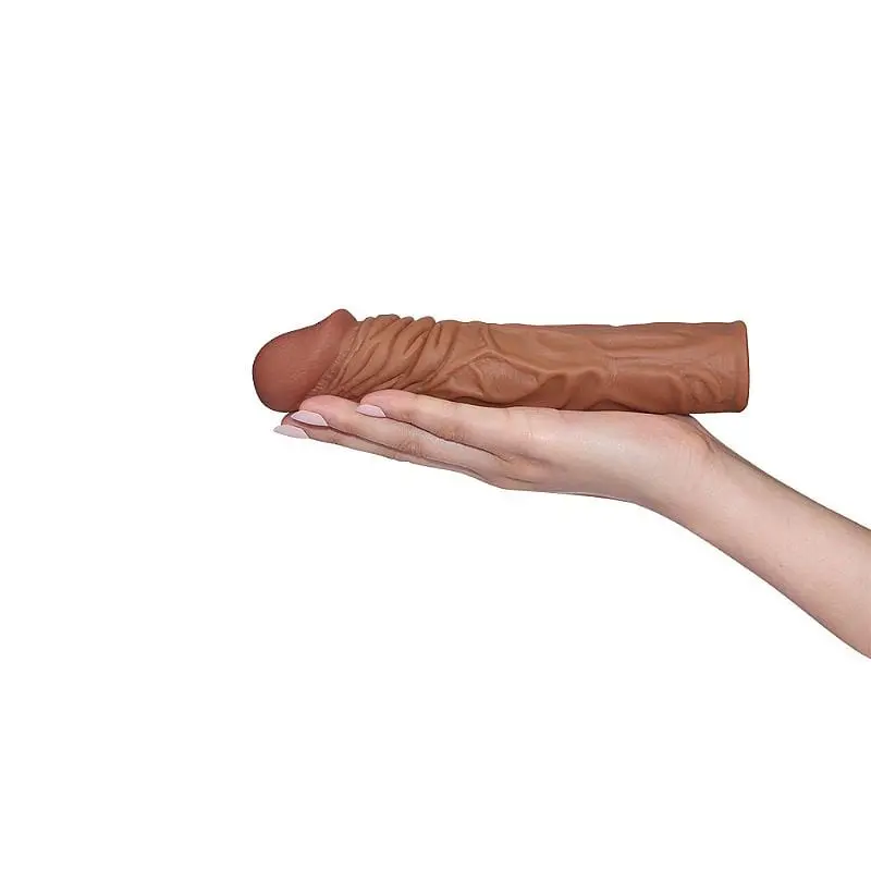 imagem de mão feminina segurando capa peniana em cyberskin na cor marrom