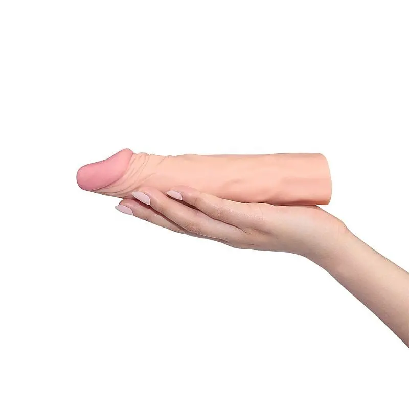 mão feminina segurando capa peniana em cyberskin cor clara mede 19 cm por 4 cm